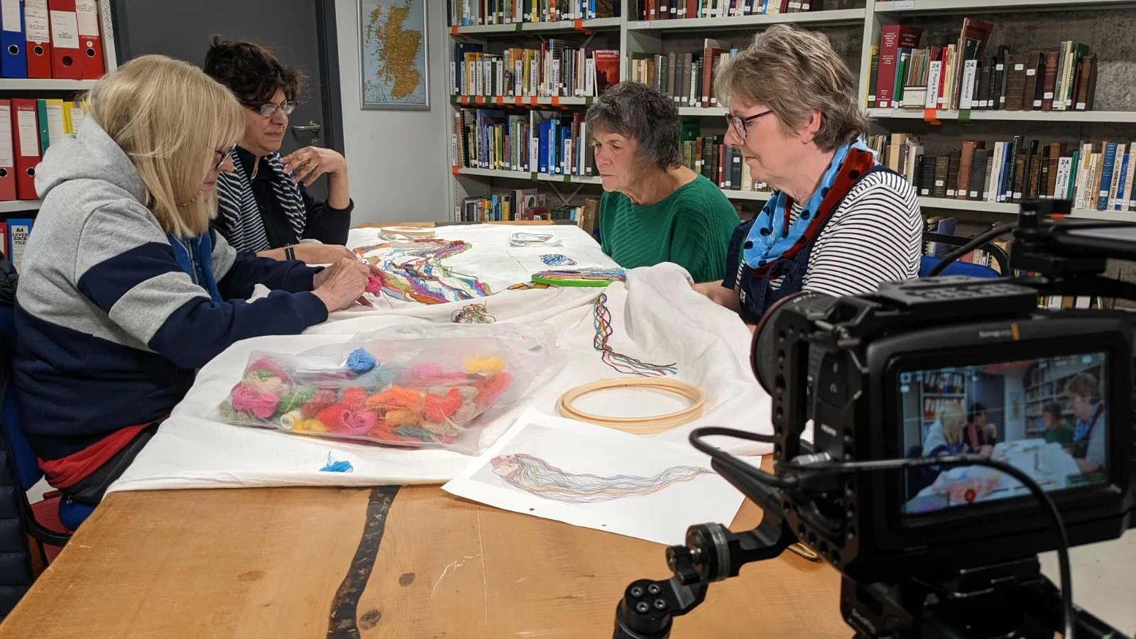 Group of Women showing to camera the tapestry their are working on for the Digital Tapestry of the Scottish Highlands and Islands project