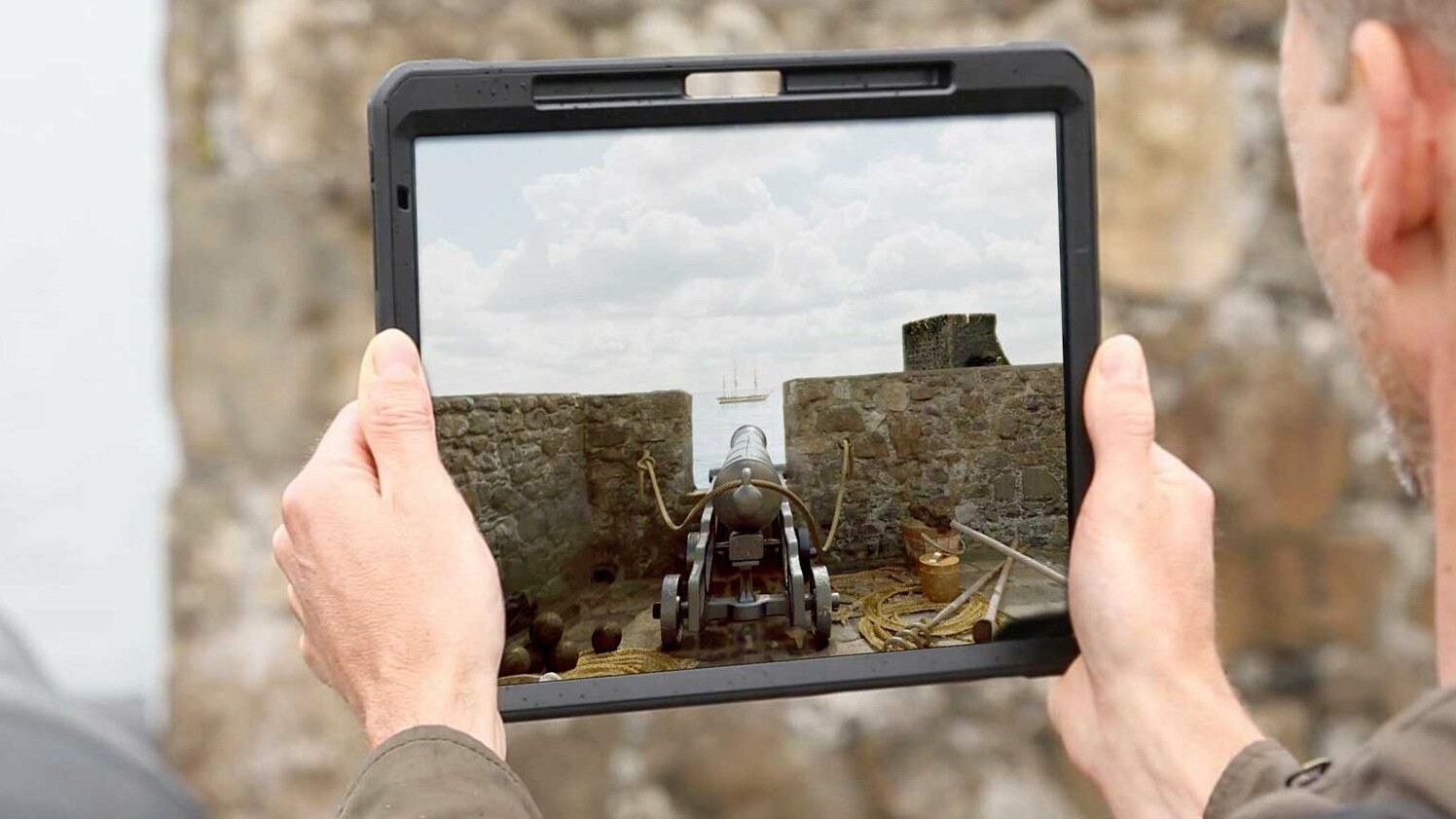 Person using AR (Augmented Reality app) for augmented reality castle. Carrickfergus