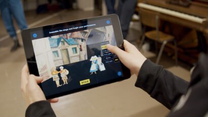 Person holding ipad using the Making a Scene app, an AR theatre careers app for a mixed reality educational loan box for University of Bristol Theatre Collection and Bristol Old Vic.