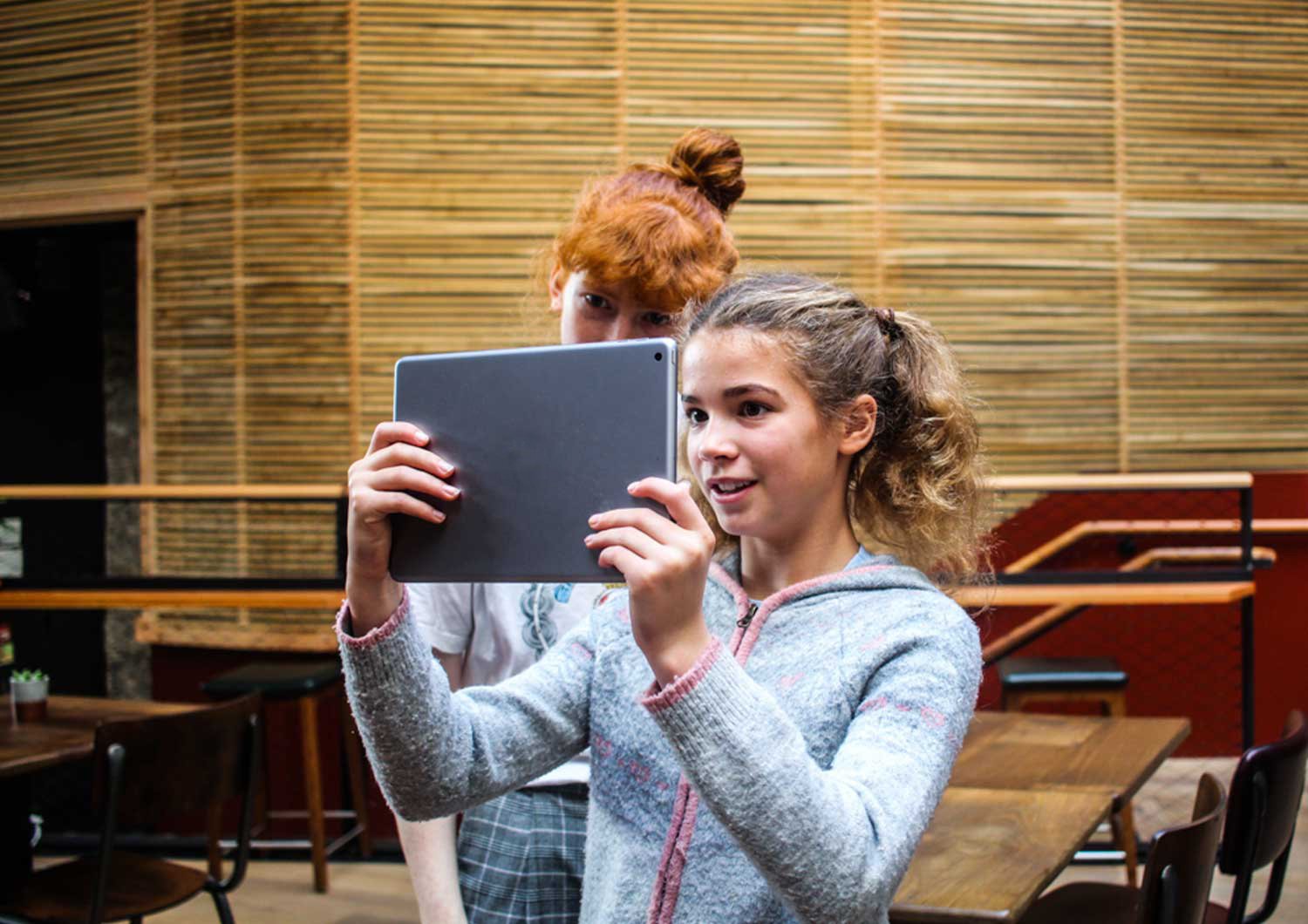 Two girls trying the Window to the past Augmented reality app for Bristol Old Vic. augmented reality history tour