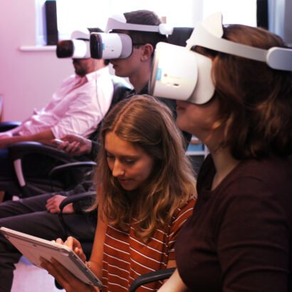 3 people with a virtual reality headset testing Limina VR cinema experience