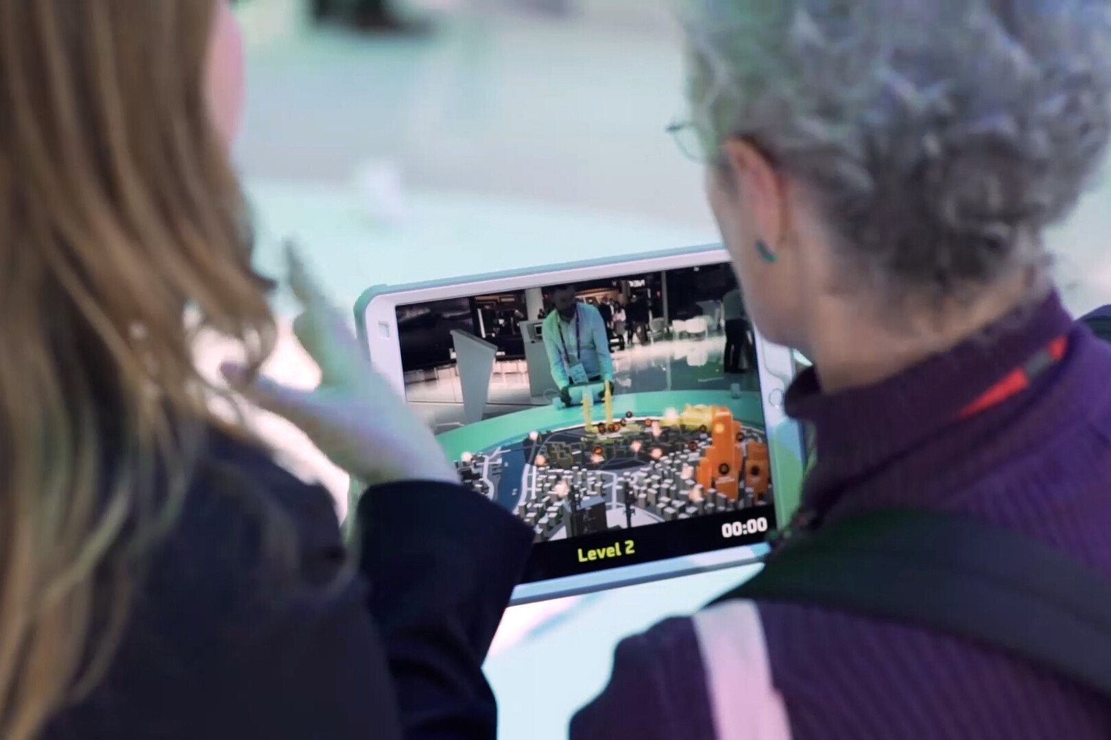 Two people trying Cyber security AR city game in an iPad