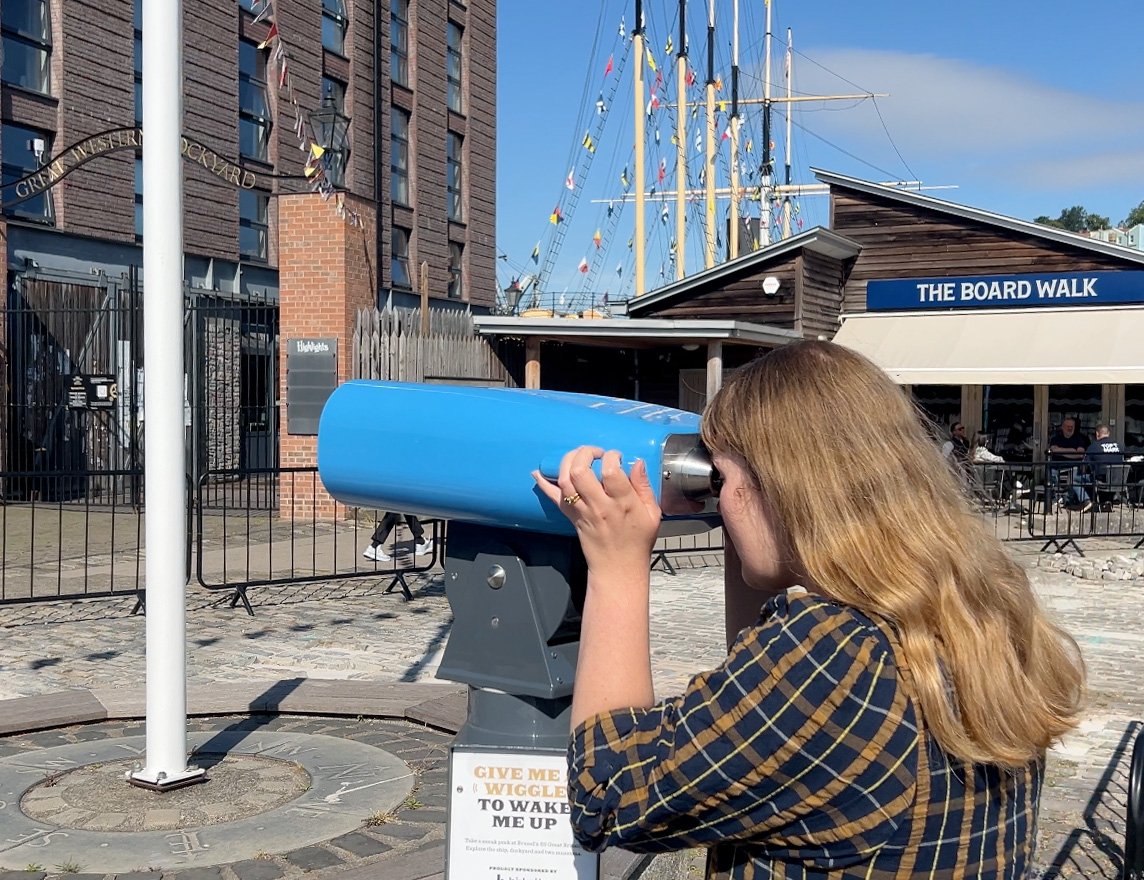 Person looking through SSGB Virtual reality binoculars installed in Bristol Harbourside. Tempting ticket sales with VR binoculars at SSGB
