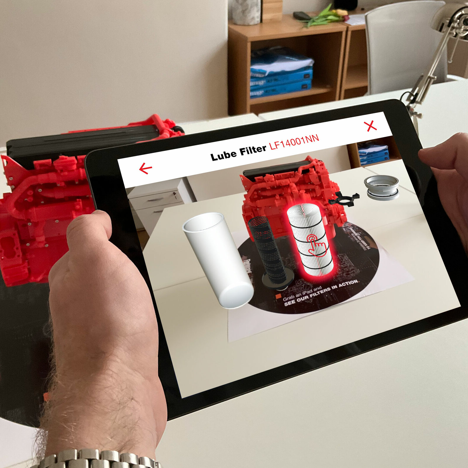 Fleetguard AR app on a tablet showing a 3D lube filter demonstration on an engine.