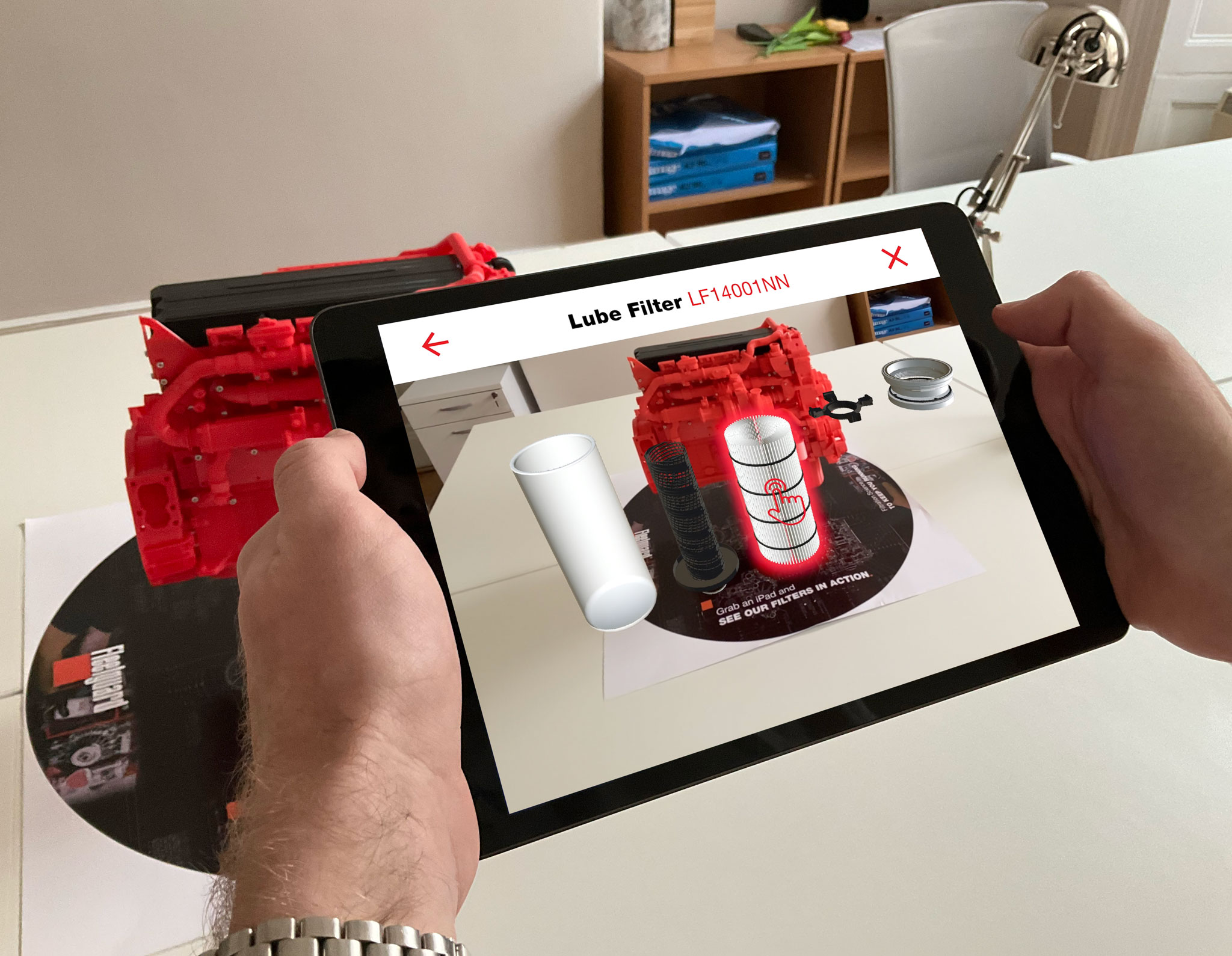 Fleetguard AR app on a tablet showing a 3D lube filter demonstration on an engine.