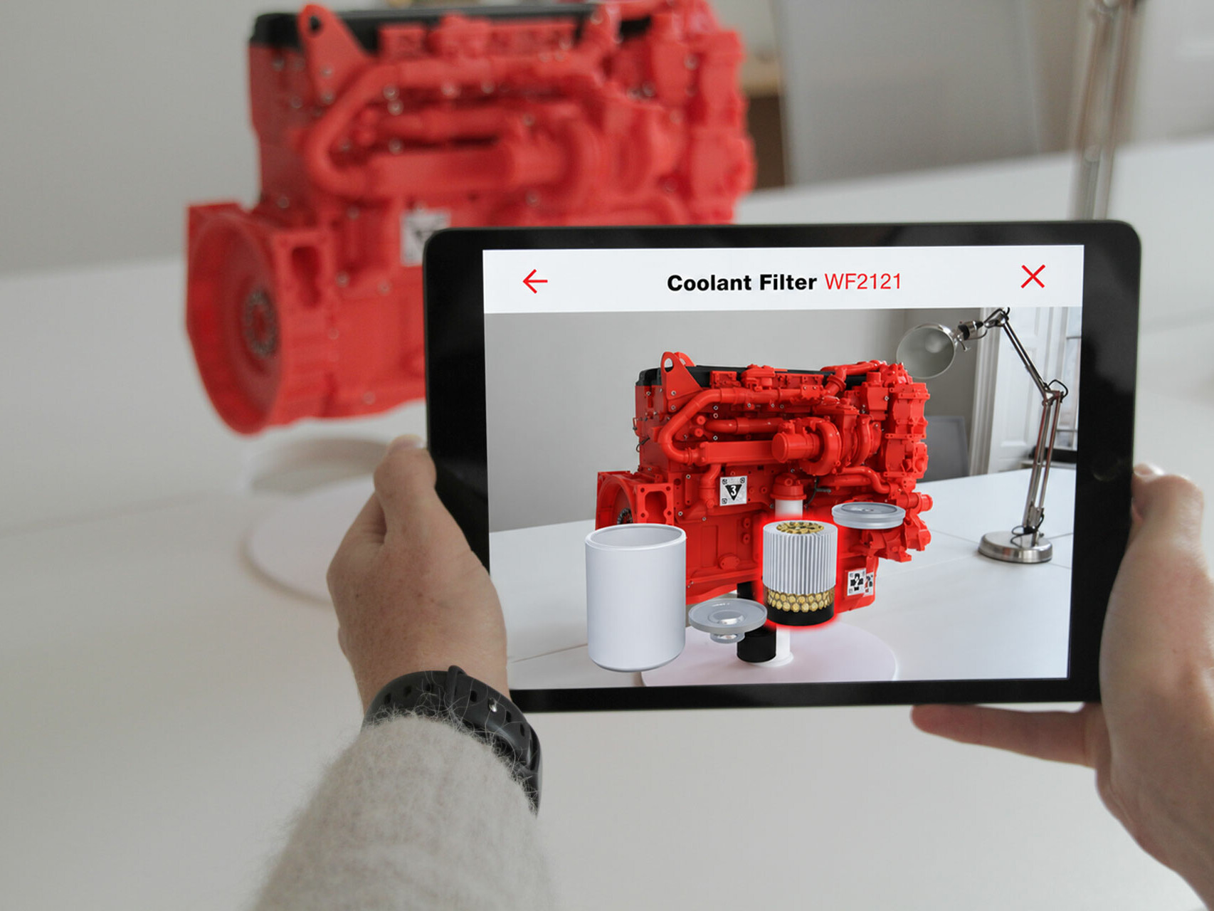 Fleetguard AR app on a tablet showing an interactive engine and lube filter demonstration, helping users see how a filter works in augmented reality.